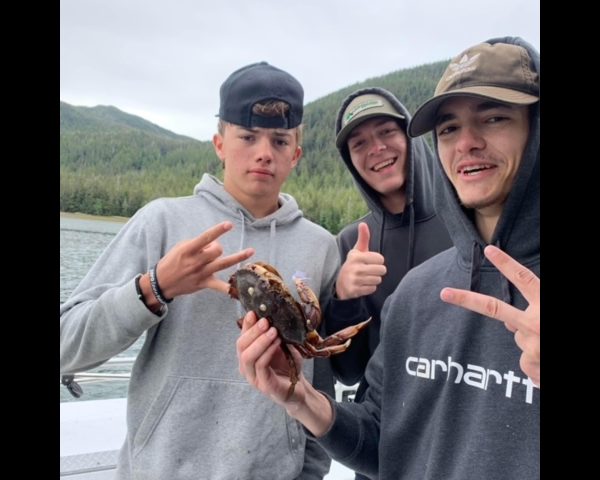 3 young boys holding a crab
